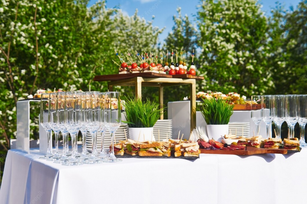 buffet-open-air-table-with-canapes-glasses-against-background-flowering-trees-sky_533998-5406.jpg